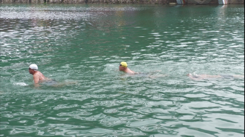 游泳爱好者们在龙川河里冬泳。