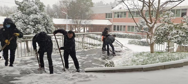 图为：县中心敬老院干部职工为方便老年人安全行走在人行道上铲冰除雪