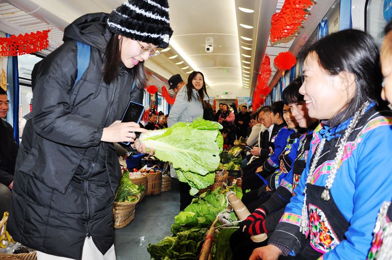 旅客兴致昂扬的在乡村集市里挑选新鲜蔬菜。杨道军摄