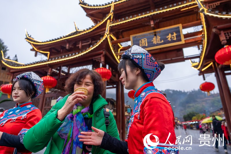 团龙村“幸福土家过赶年”活动现场，游客品尝拦门酒。人民网记者 涂敏摄