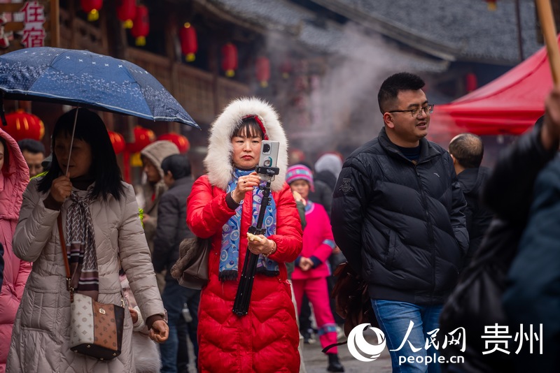 游客拍攝團龍村“趕年”盛況。人民網記者 涂敏攝
