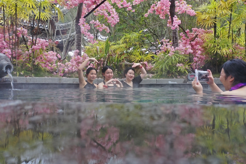 游客在剑河鲜花簇拥的汤池里泡温泉。杨家孟摄