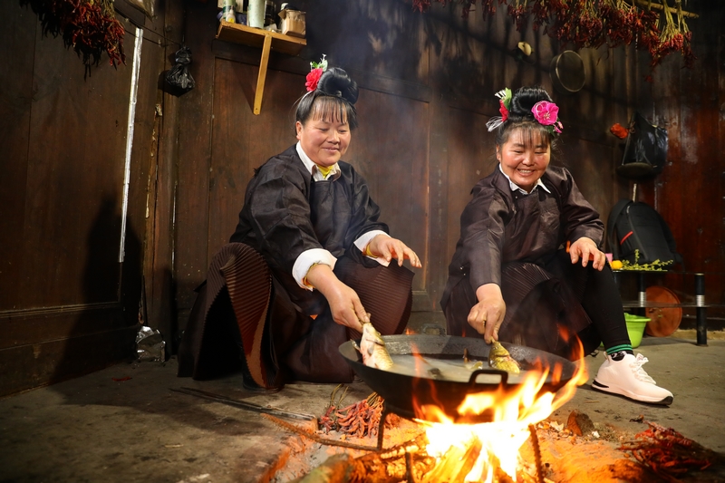 村民在烹煮酸汤鱼。