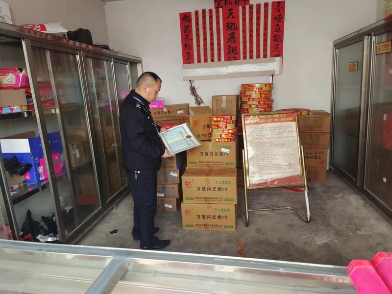 工作人员查看经营者是否具备烟花爆竹销售资质。