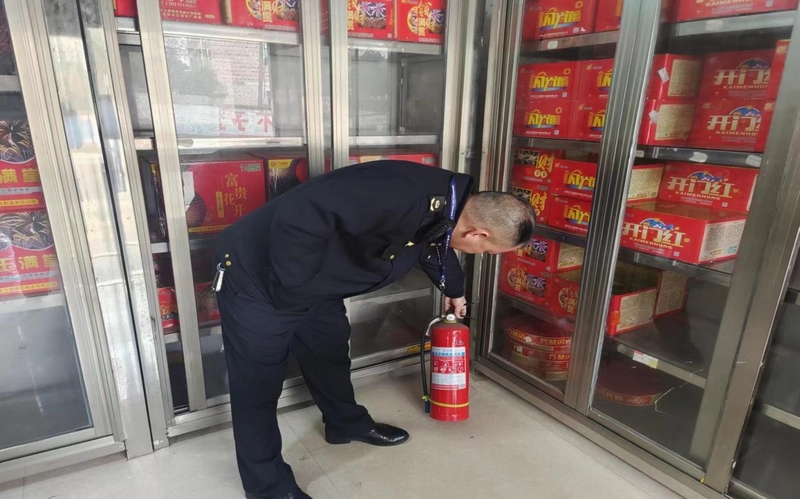 工作人员查看烟花爆竹零售店消防设施配备情况。