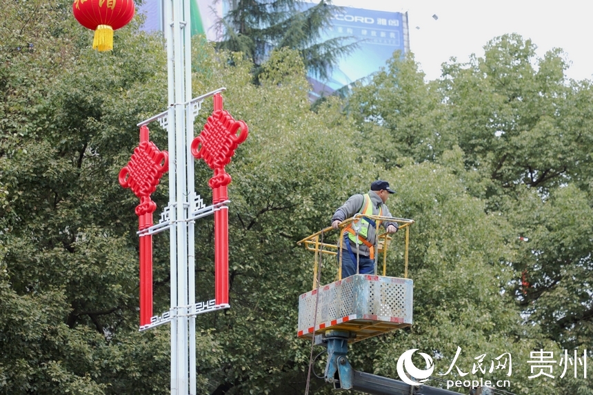 工人在主干道悬挂中国结。人民网 顾兰云摄