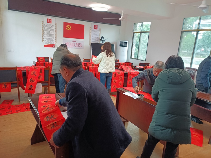 朱天村组织书法爱好者为村民写对联。