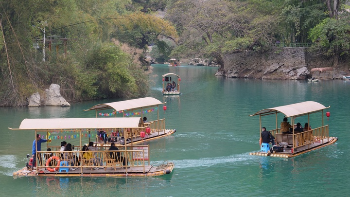 游客乘坐竹筏在水上泛游。