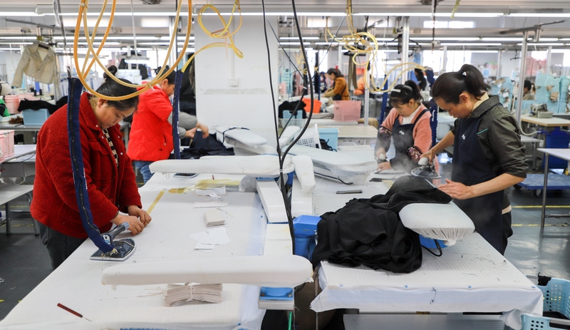2月18日，在贵州星美服饰有限公司生产车间，工人们正忙着裁边、缝线、熨烫等工作，一如往日的忙碌景象。
