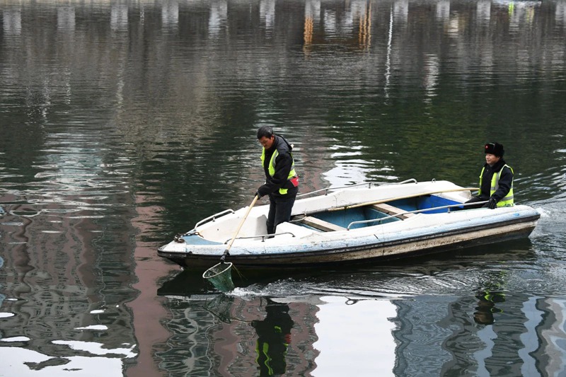 河道疏捞工人正在甲秀楼河段清理水草及水体漂浮物。