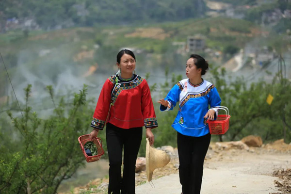 盧丹代表（左）走村入戶，與村民交心談話。