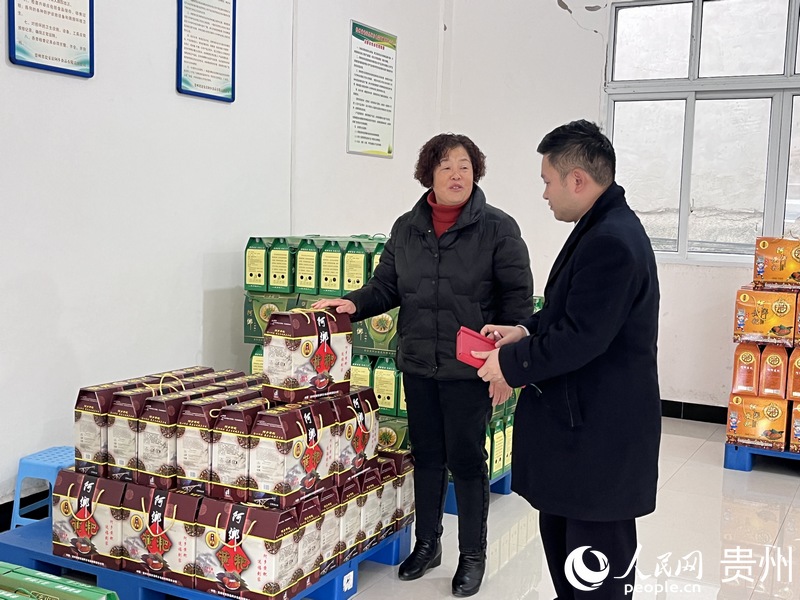 何艷正向瓮安農商銀行工作人員介紹黃粑產品。人民網 陳潔泉攝.jpg