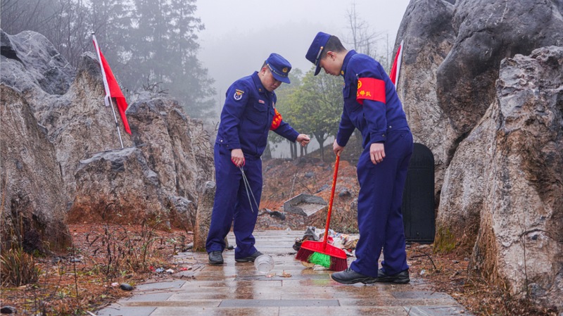 志愿者们清扫道路旁的垃圾.jpg