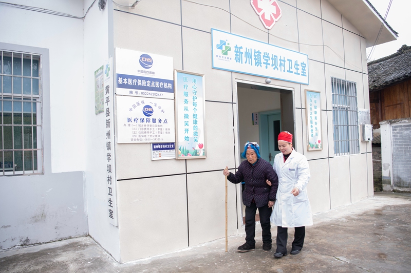 2024年3月4日，乡村医生王碧在村卫生室扶行动不便的村民。（梁文 摄）