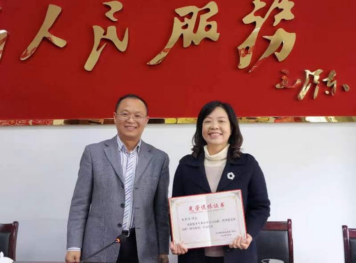 刘卓刚同志为其颁发光荣退休证书。