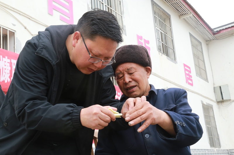 3月22日，貴州省黔西市甘棠鎮敬老院內，志願者正在給老人修剪指甲。