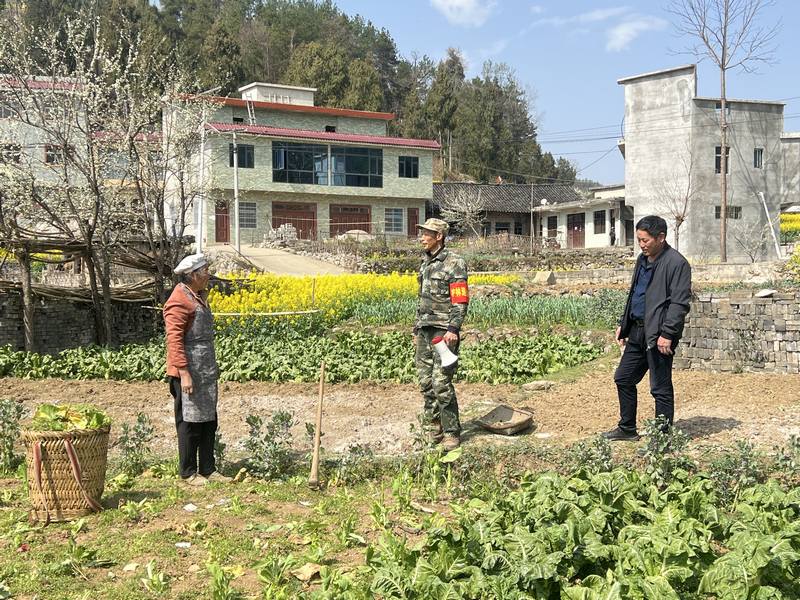 护林员何仕强在田间地头向村民宣传森林防火相关知识.jpg