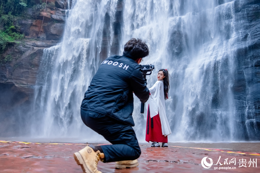 游客在瀑布前打卡拍照。人民网记者 涂敏摄