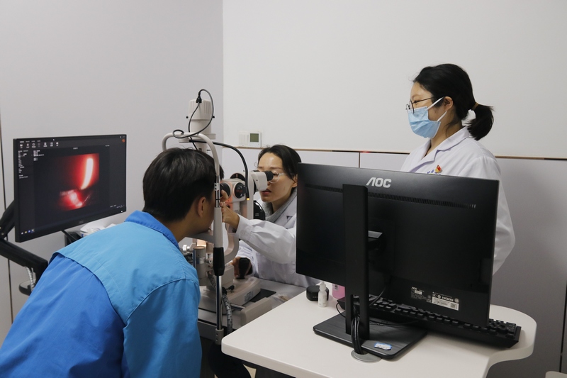 陈伟坤正在通过裂隙灯眼前段照相机给患者检查眼睛。 程建平摄
