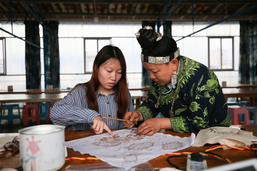 4月17日，苗族蠟染技藝傳承人在寧航蠟染非遺體驗館指導學生畫蠟畫。 