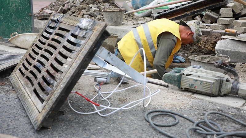 觀山湖區市政處工作人員在西二環地勢低窪易積水點安裝井蓋。