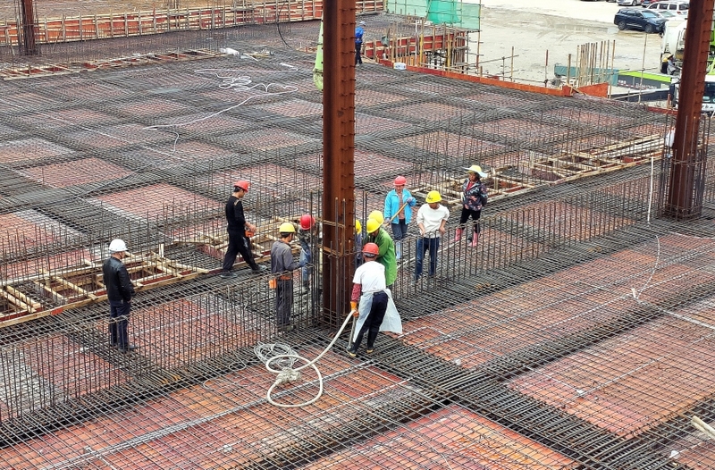 工人对瓮安第十中学项目风雨操场浇筑主梁和顶板。赵仁妃摄