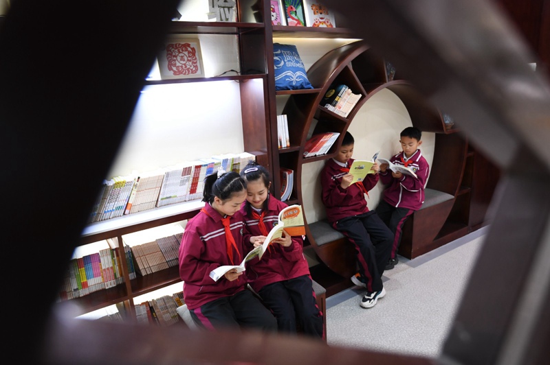 学生在校园图书角阅读书籍。