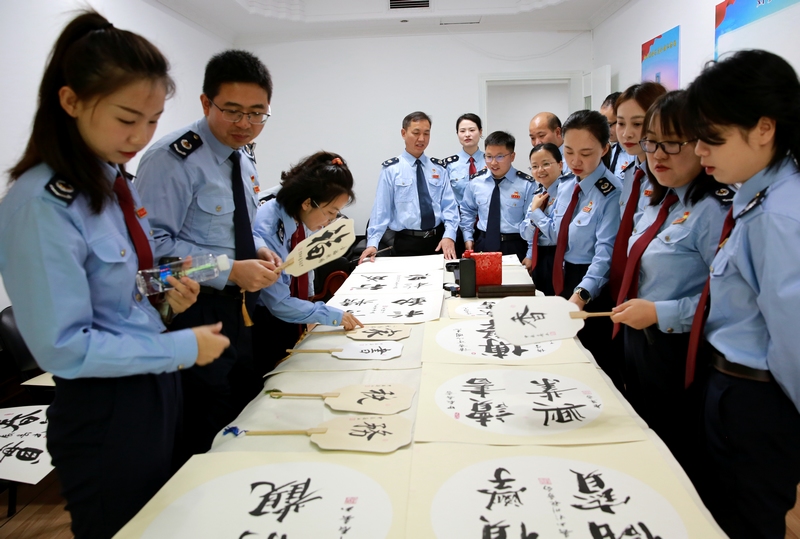 黔東南州稅務局青年干部在第29個世界讀書日之際，開展“讀書礪使命、書香潤初心”主題讀書活動。圖為青年干部開展書法分享活動。李德業攝