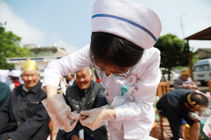 醫務人員和志願者在貴州省黔西市林泉鎮敬老院為老人剪指甲。