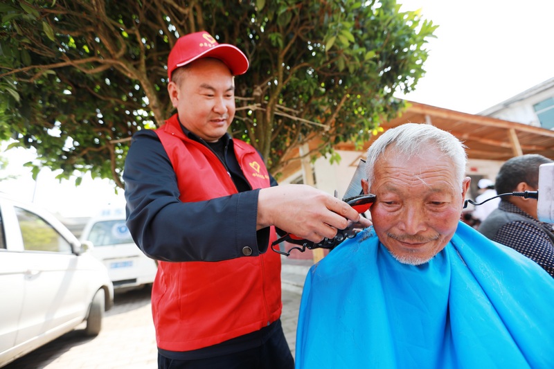 醫務人員和志願者在貴州省黔西市林泉鎮敬老院為老人理發。