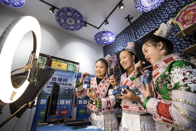 新仁苗族乡化屋村易地扶贫搬迁安置点就业车间，村民直播苗绣蜡染产品。史开心摄