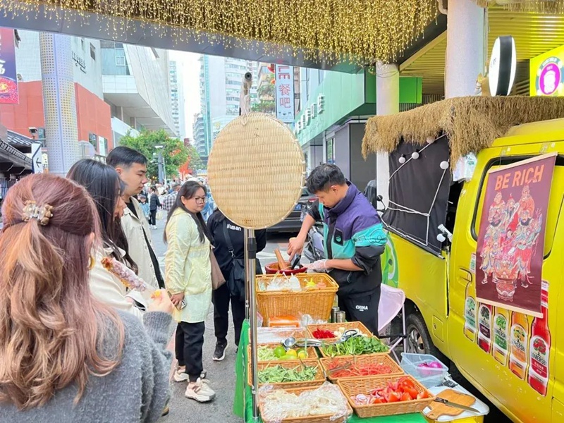 小吃摊前围拢的食客。