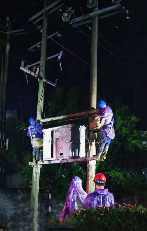 3、南方电网兴仁供电局工作人员冒雨对受雷击故障台区变压器进行更换复电。