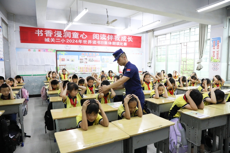 图为消防员在指导学生自救演练。杨婷摄