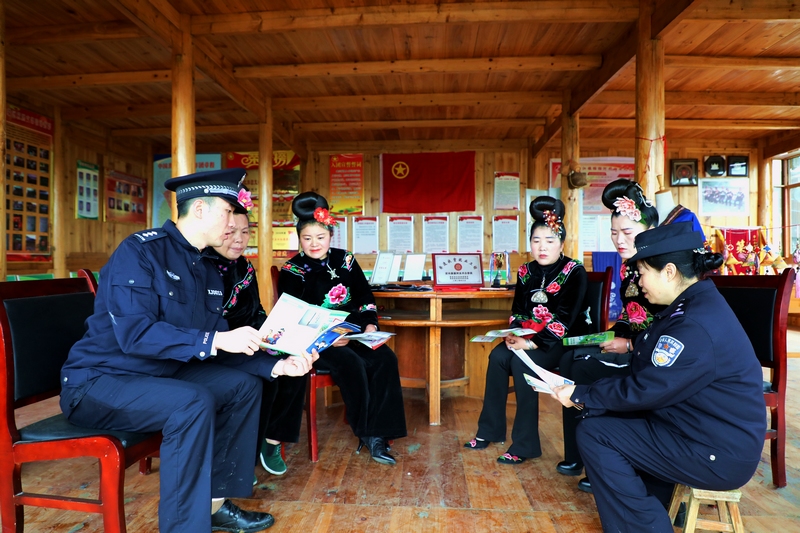 雷山縣公安局黨員民警向轄區村民發放講解禁毒宣傳資料