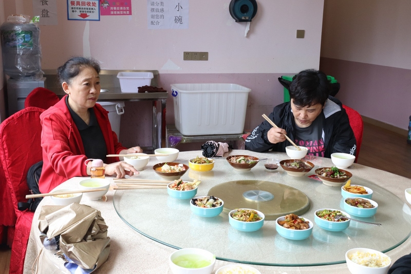 (2)社区老人们一起分享社区食堂美味的菜肴 刘麟 摄