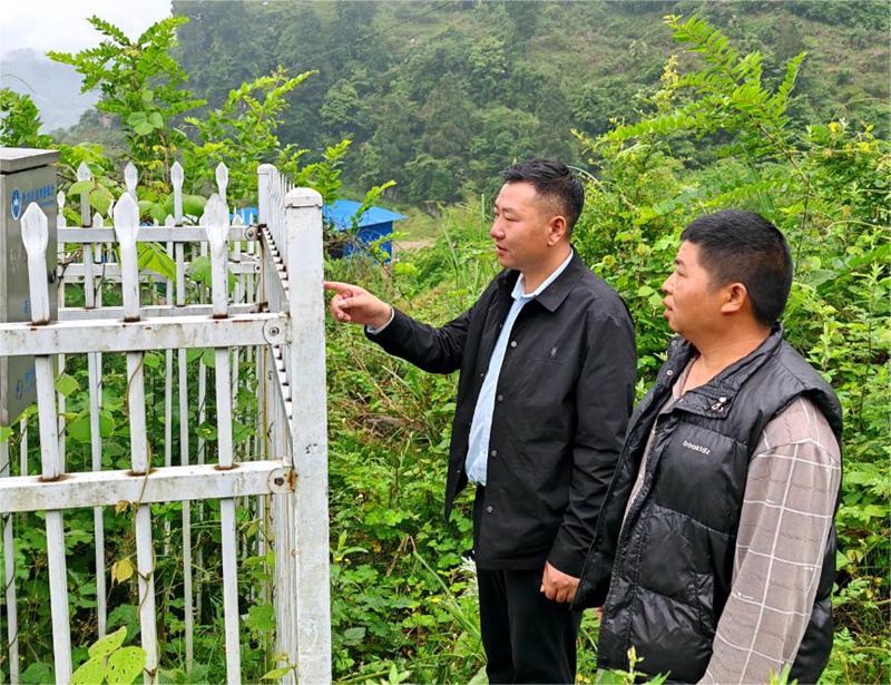 天水池村村党支部书记陈德飞和监测员张少廉一起查看地灾隐患点情况。