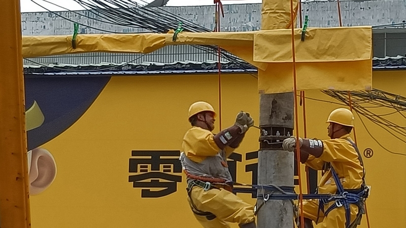 工作人员正在对电杆连接安装 修文县供电局罗志勇 摄