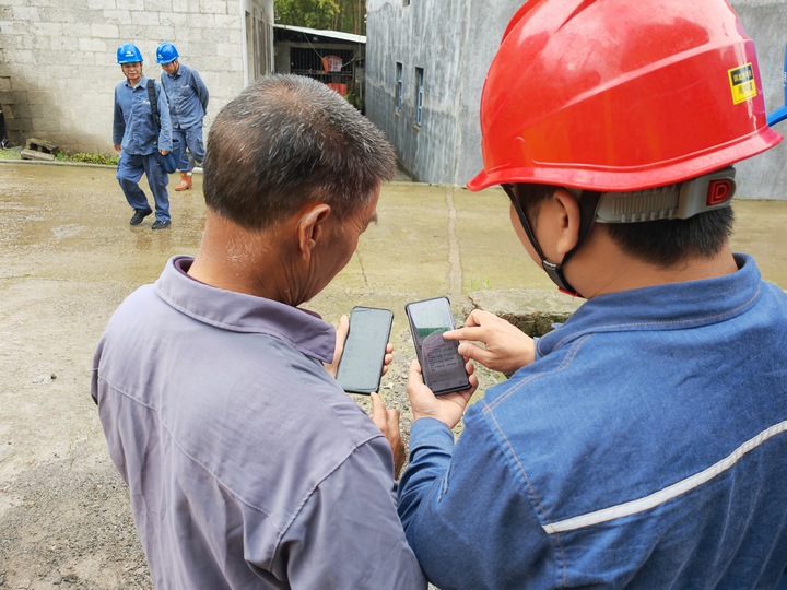 南方電網興仁供電局工作人員對供電轄區內用電群眾推廣“黔電小哥”。