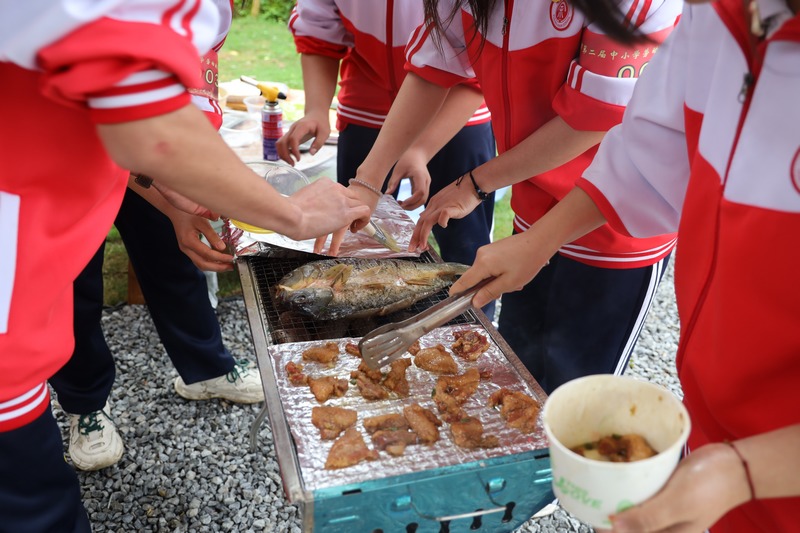 學生們相互配合烤魚、烤肉。