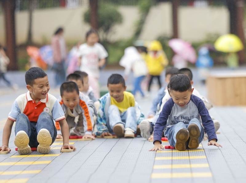 6月7日，在贵州省黔东南苗族侗族自治州施秉县第四幼儿园，小朋友在玩划龙船游戏。磨桂宾摄