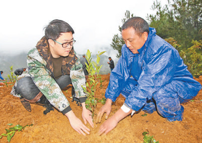 2018年10月，張勇（右）和黃杜村群眾共同栽下第一株茶苗。沿河縣委宣傳部供圖