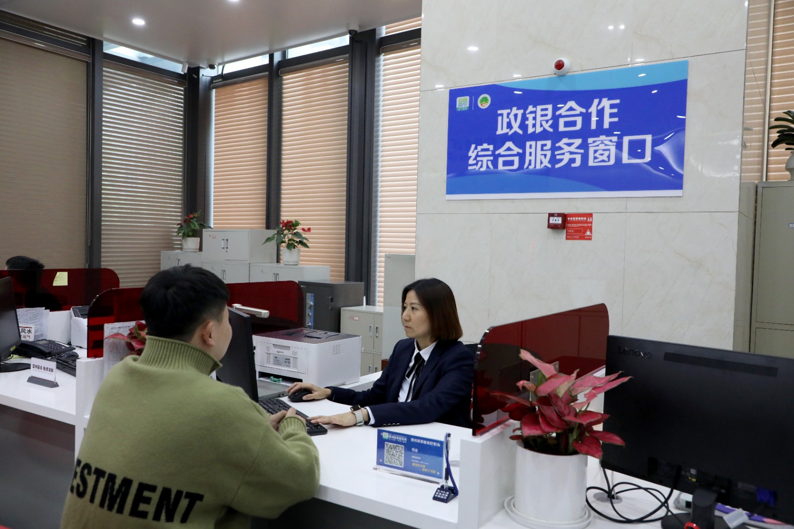 办事群众在银行窗口办理业务。