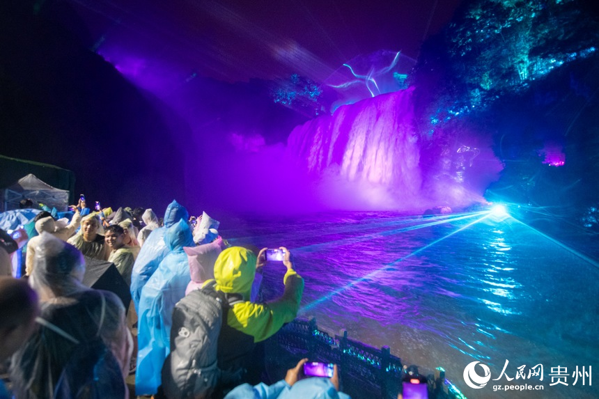 6月23日，游客夜游黄果树瀑布，观赏大型灯光秀，感受与日间游玩不一样的旅游体验。人民网记者 翁奇羽摄