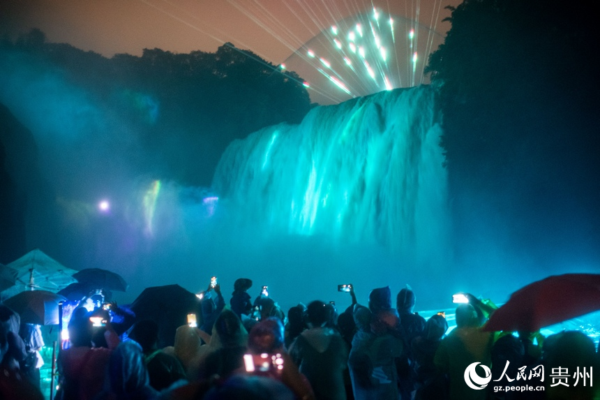6月23日，游客夜游黄果树瀑布，观赏大型灯光秀，感受与日间游玩不一样的旅游体验。人民网记者 翁奇羽摄