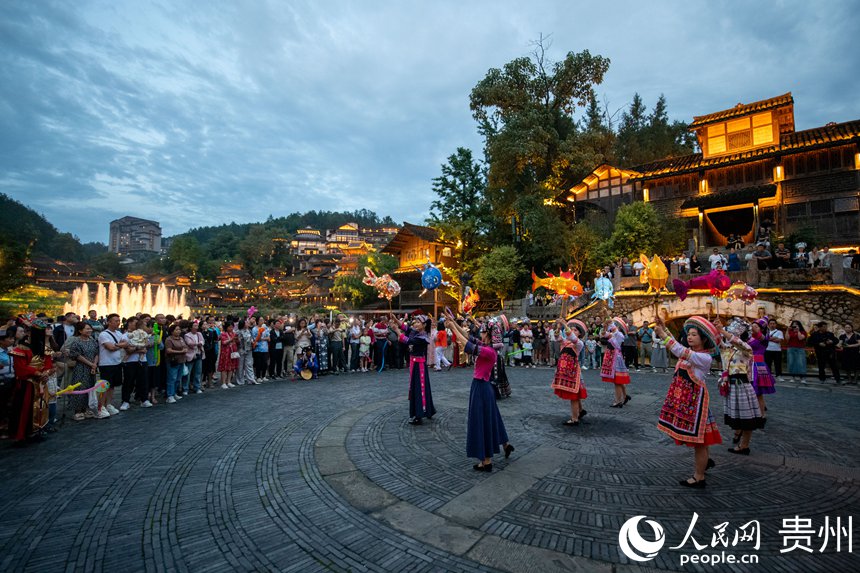 6月24日，在乌江寨景区，传统民俗表演吸引众多游客驻足观赏。人民网记者 翁奇羽摄