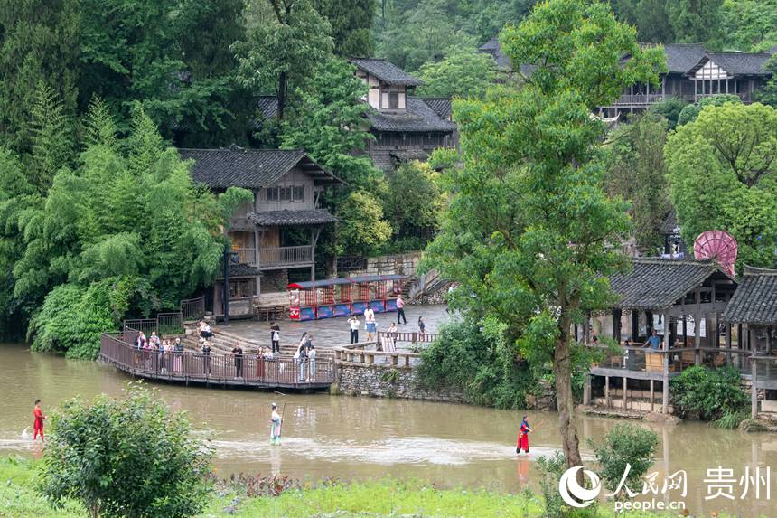 6月24日，在乌江寨景区，独竹漂表演吸引游客驻足观赏。人民网记者 翁奇羽摄