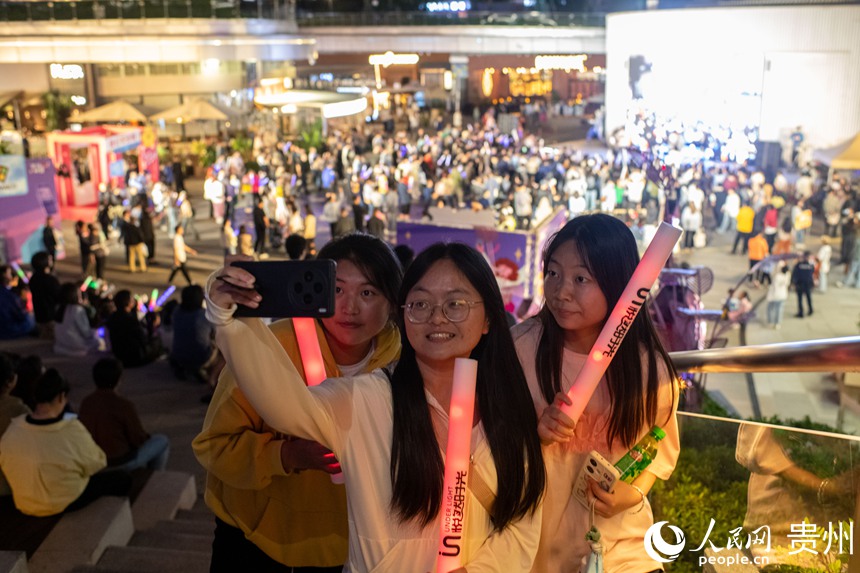 6月26日晚，在贵阳市观山湖路边音乐会现场，观众自拍留念。人民网记者 翁奇羽摄