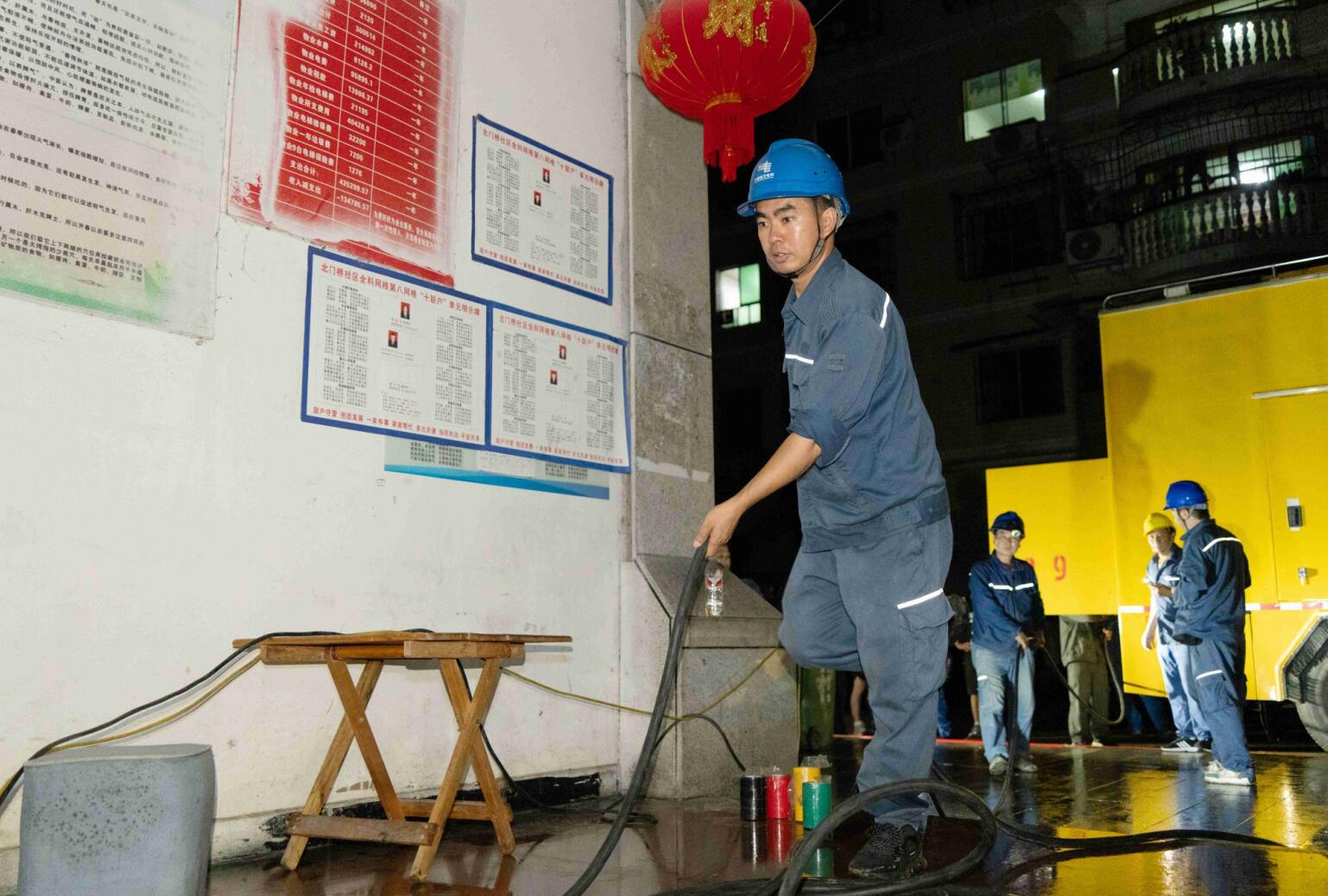 铜仁玉屏供电局应急保电人员将应急发电车接入宏发铭都小区接入口进行保电工作。车安南摄