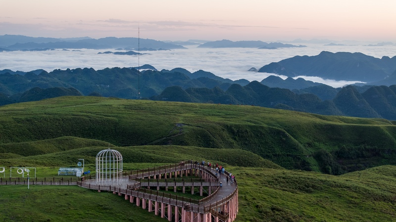 7月2日，游客在贵州省毕节市赫章县阿西里西大草原景区观看日出、云海。陈春志摄